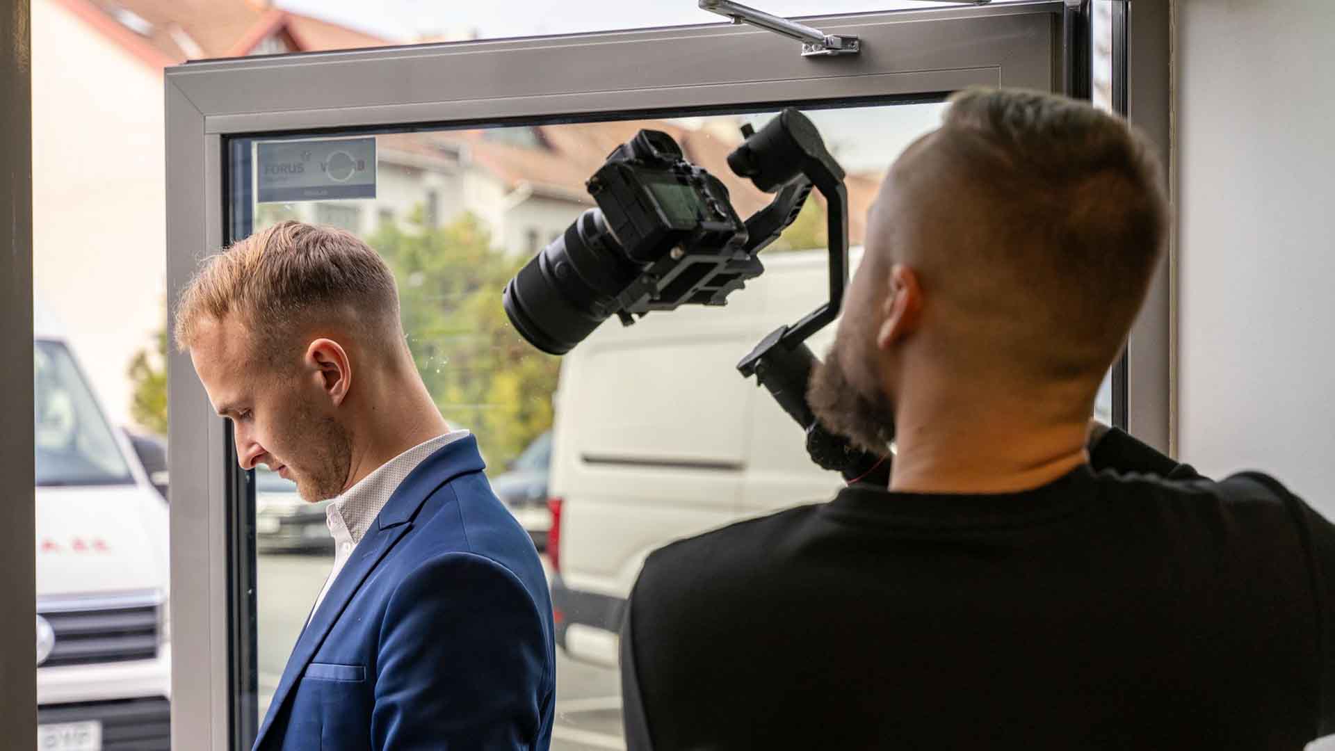a man in a suit and a man with a camera